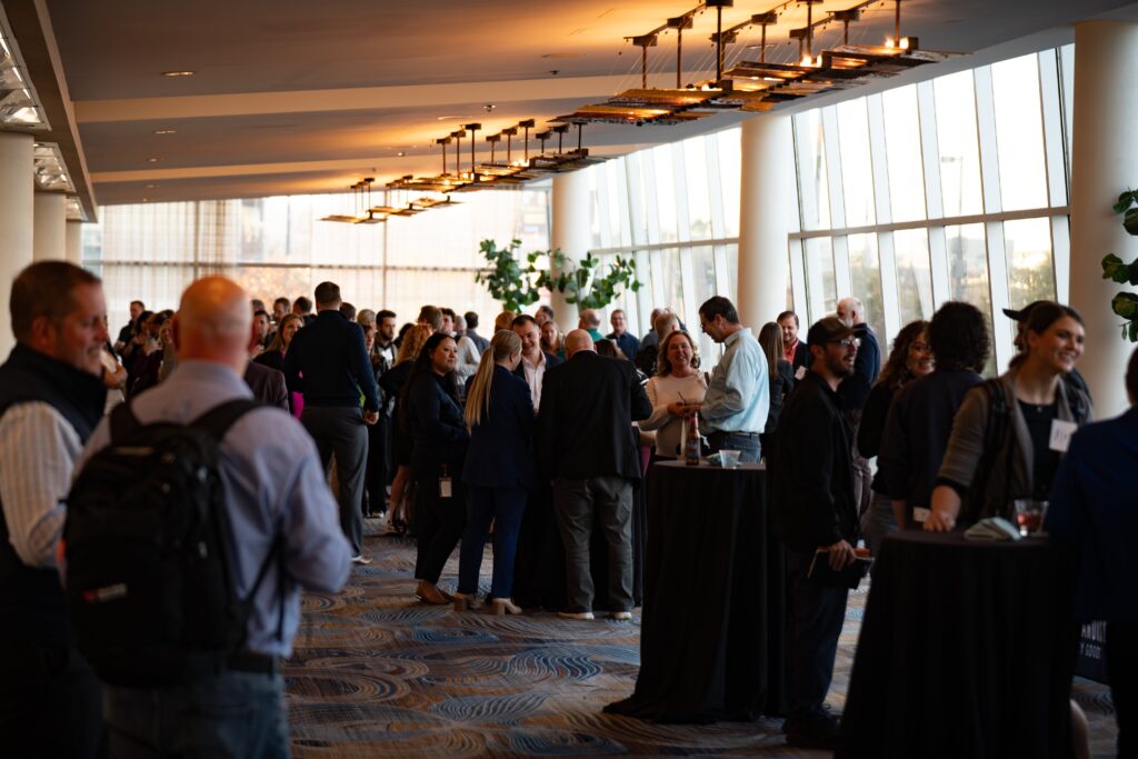 A large, bright room filled with people conversing over drinks 